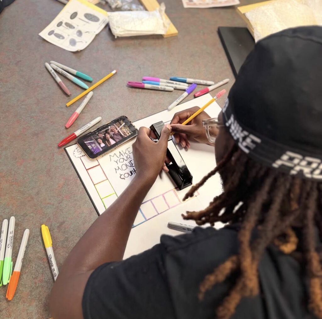 A YAC member designing a Make Your Money Count board game