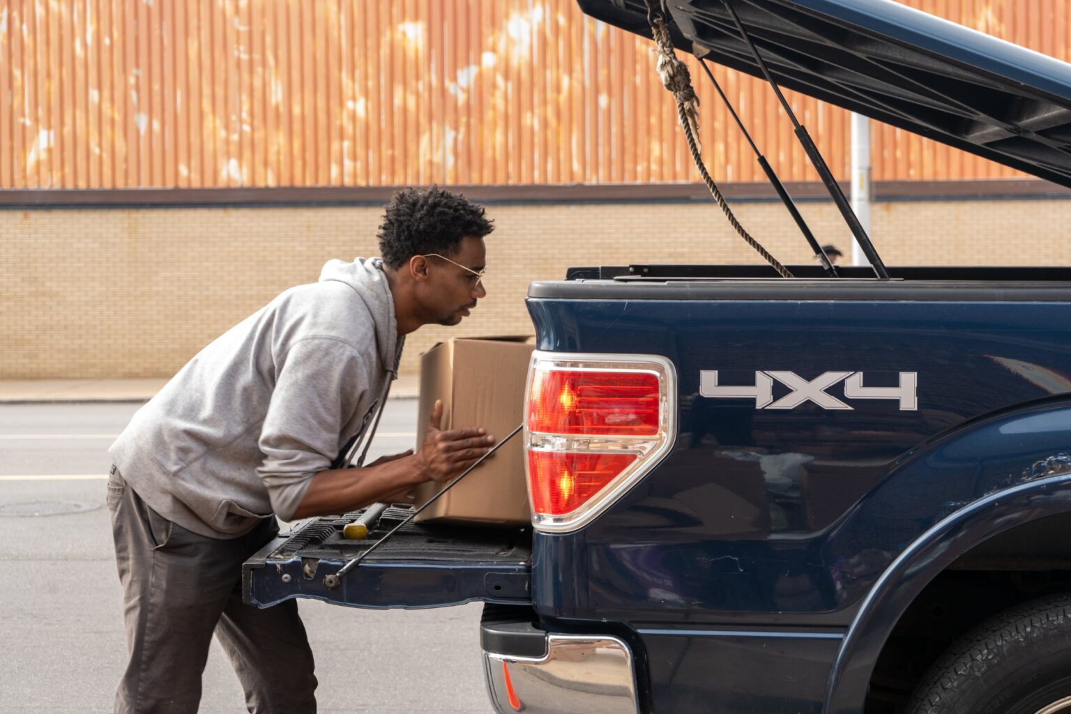 A volunteer loading a box of food into a truck