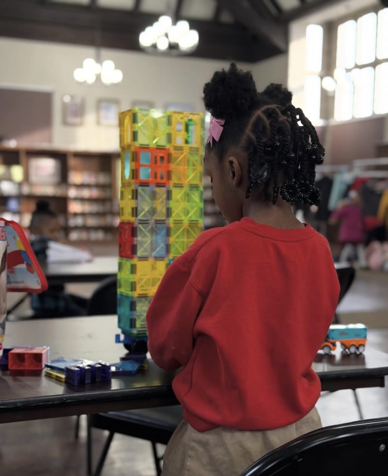 A child building a tower with magnetic tiles