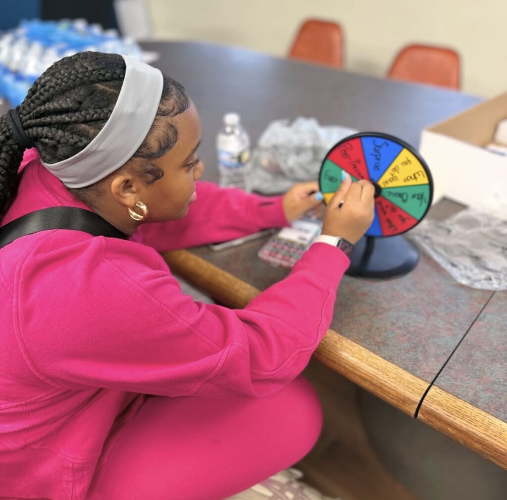 A teen filling in a goal-setting spinner wheel